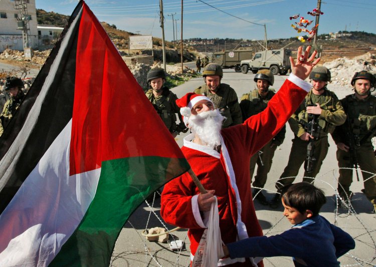 Santa Clause in the village of Masara handing candy to the children south of Bethlehem